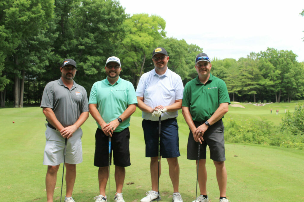 Four men golfing on a green course