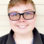 Person smiling with glasses and short hair