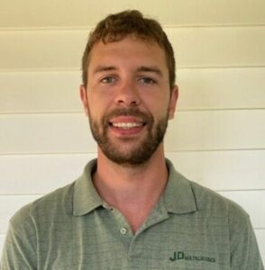 Smiling man in gray polo shirt.