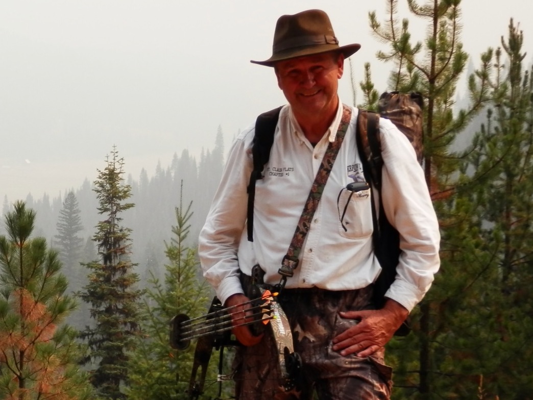 Man with bow hiking in forest