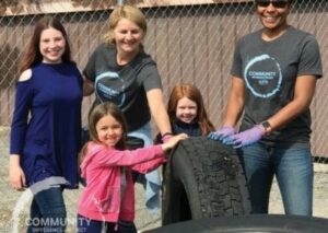 Group lifting a tire for community project