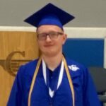 Graduate in blue cap and gown with medals