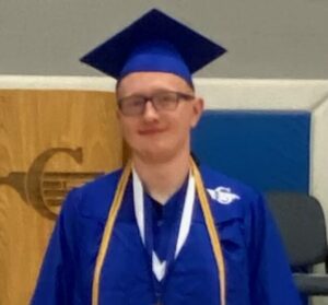 Graduate in blue cap and gown with medals