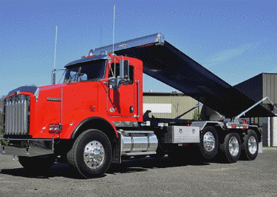 Red dump truck unloading at construction site