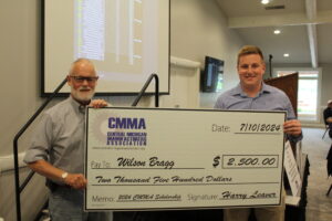 Two men holding scholarship check from CMMA.