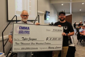 Two men holding large scholarship check.