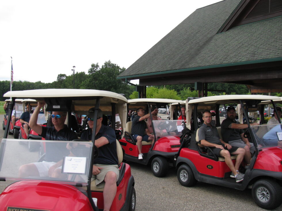 Group of people in golf carts near building