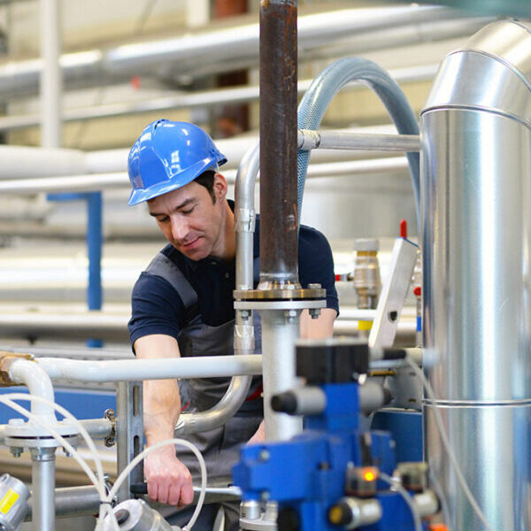 Engineer inspecting industrial machinery pipes