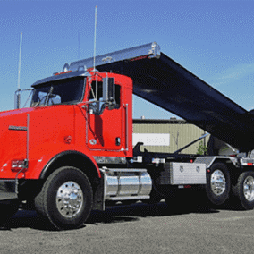 Red dump truck unloading at construction site